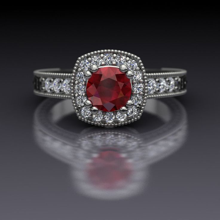 a ring with a red stone surrounded by white diamonds on a reflective surface in front of a black background