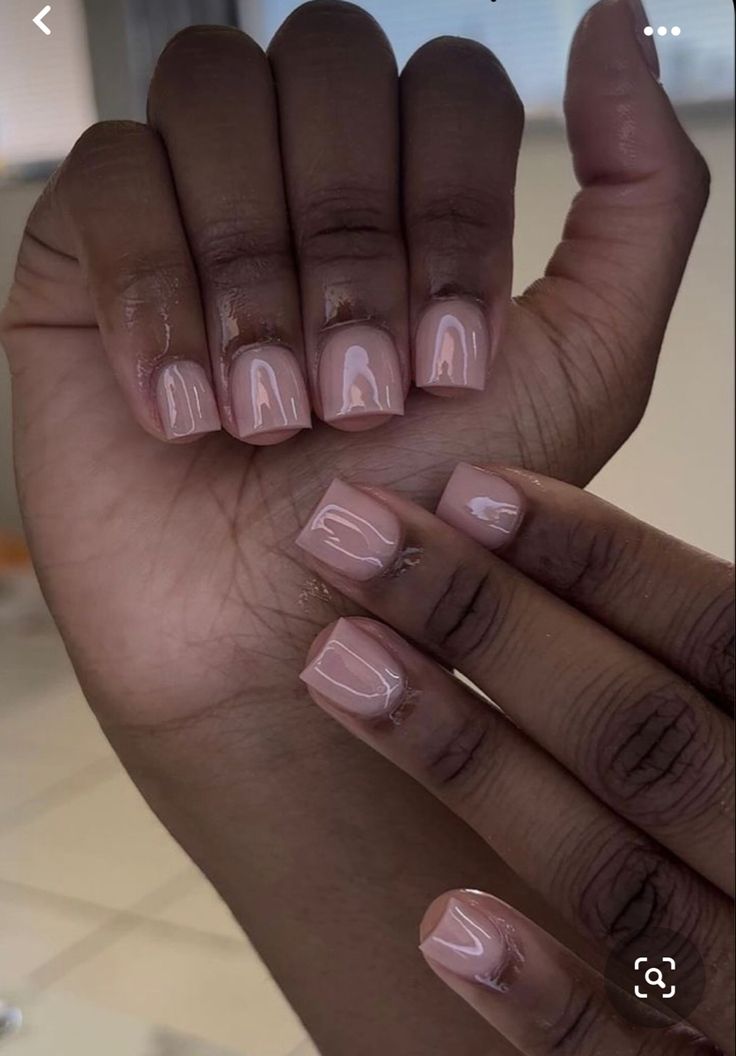 a woman's hand with some pink nail polish on it