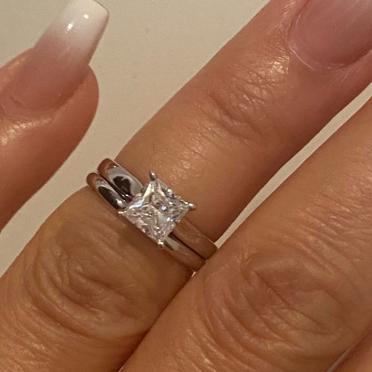 a woman's hand with a ring on it and a diamond in the middle