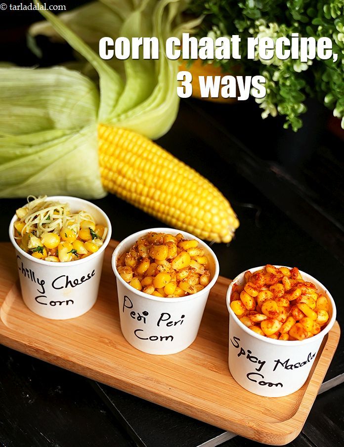 corn on the cob and three small cups with different types of food in them