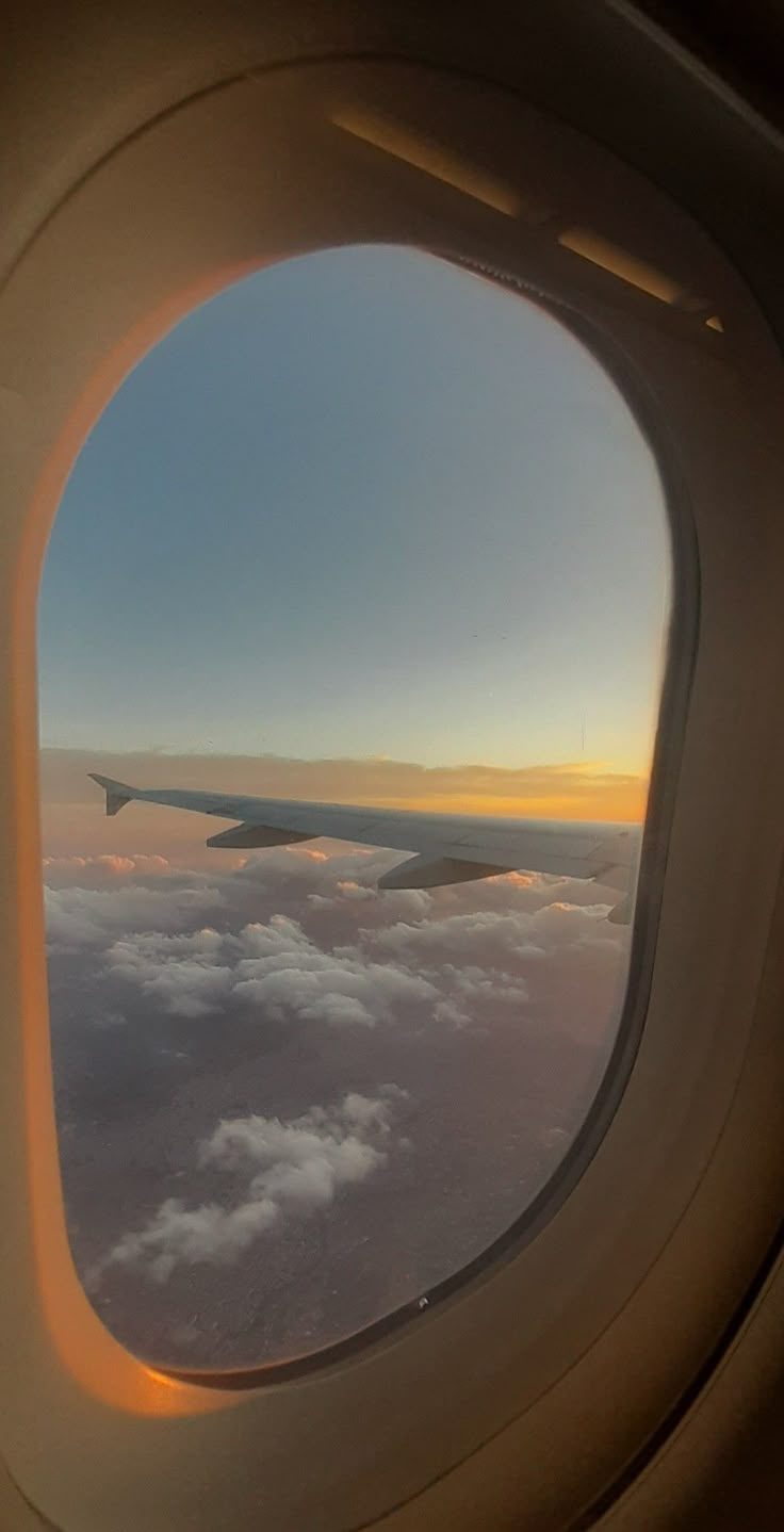 an airplane window looking out at the clouds