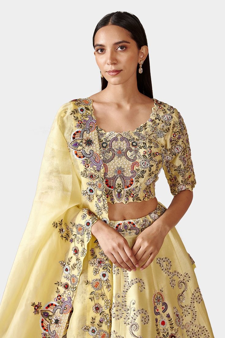 Lemon yellow lehenga with floral embroidered motifs and gota patti trims. Comes with blouse and dupatta.
Component: 3
Pattern: Embroidery
Type Of Work: Gota Patti, Zardozi, Moti and Dabka
Neckline: Scoop
Sleeve Type: Half
Fabric: Raw Silk and Organza
Color: Yellow
Other Details: 
Cutwork detail on blouse hems
Dupatta with embroidered and cutwork border
Lehenga with side tie up
Closure: Side zip
Occasion: Bride - Aza Fashions Lemon Yellow Lehenga, Organza Embroidery, Yellow Lehenga, Embroidered Motifs, Hem Blouse, Pattern Embroidery, Lemon Yellow, Bridal Lehenga, Cut Work