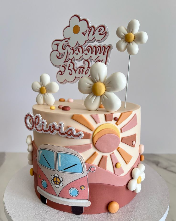 a birthday cake decorated with flowers and an old vw camper van on top