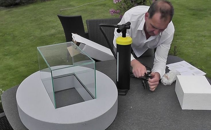 a man kneeling down on top of a table next to boxes and a yellow object