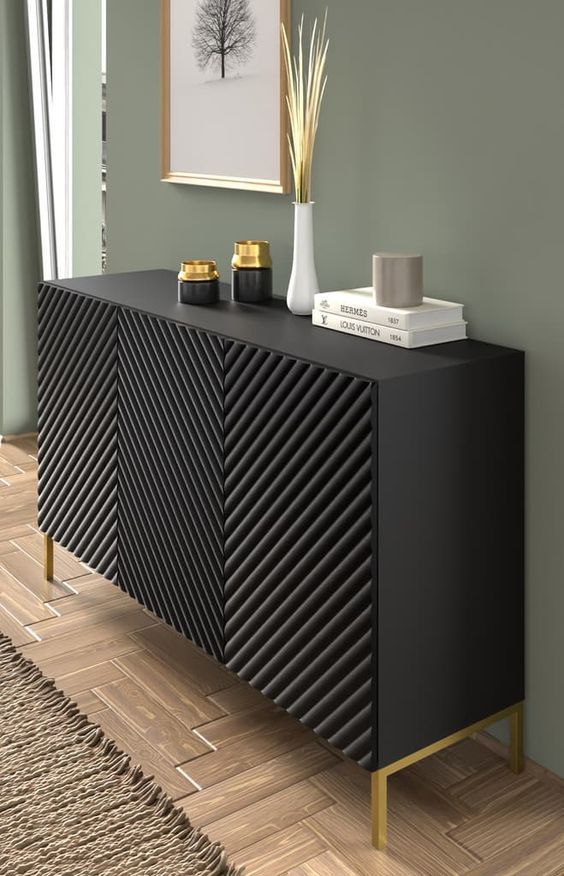 a black and gold sideboard sitting on top of a wooden floor