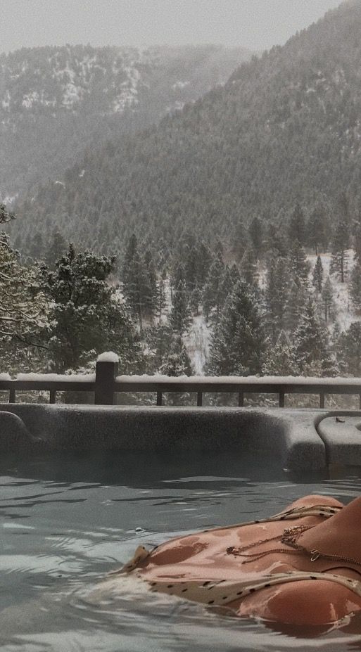 a hot tub in the middle of a snow covered mountain