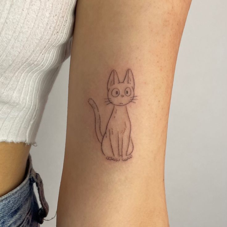 a small cat tattoo on the left side of the right arm is shown in black ink