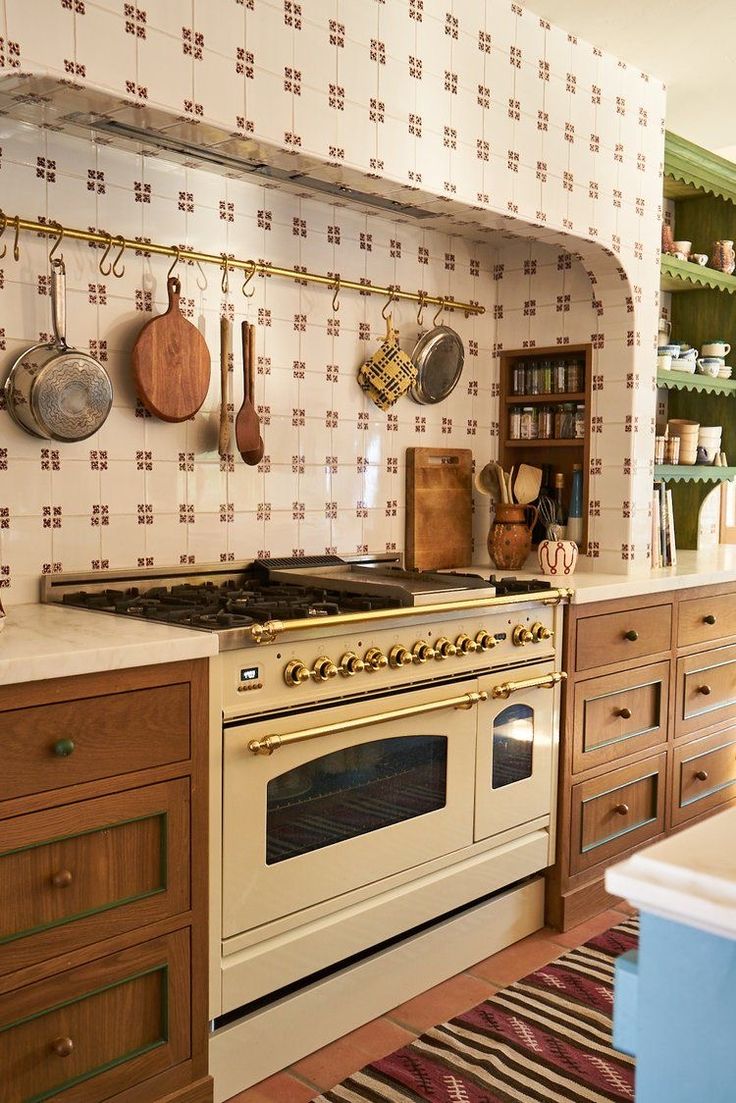 an old fashioned stove in a kitchen with wooden cabinets and hanging utensils on the wall