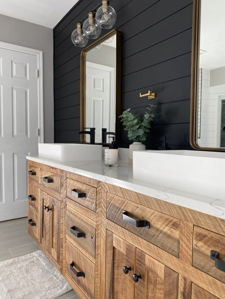 a bathroom with black walls and white counter tops, wooden cabinets and drawers on the side