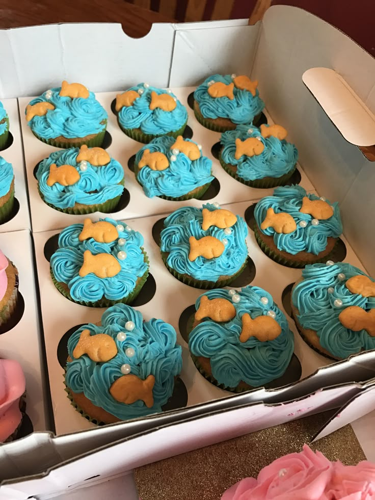 a box filled with blue and pink cupcakes