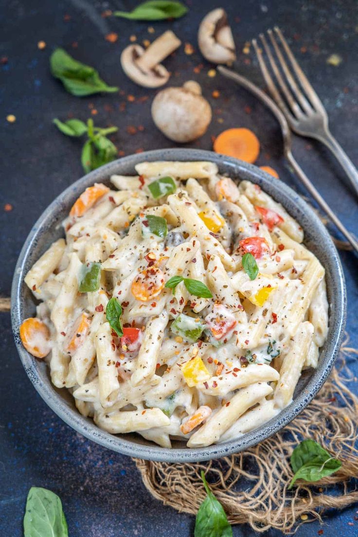 a bowl filled with pasta and vegetables on top of a table