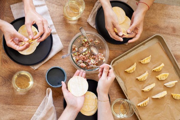 several people are making food at a table