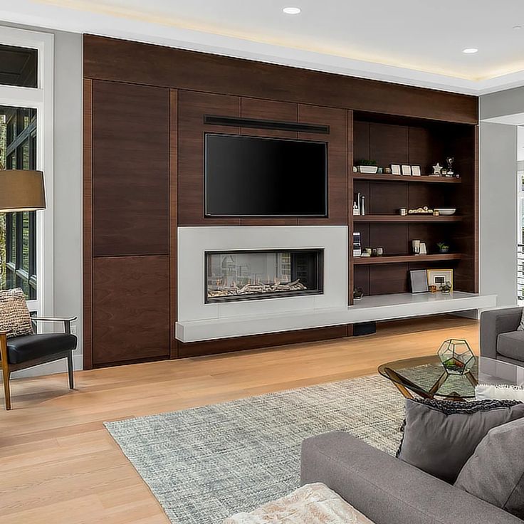 a living room with couches and a television mounted on a wall above the fireplace