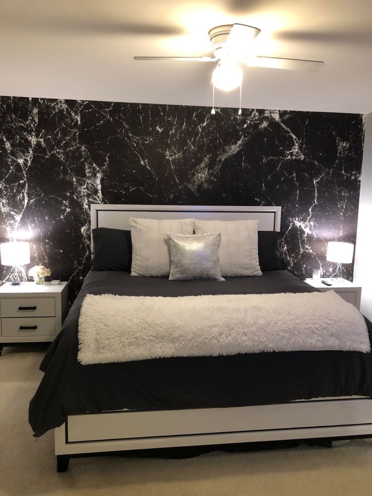 a black and white bedroom with marble walls