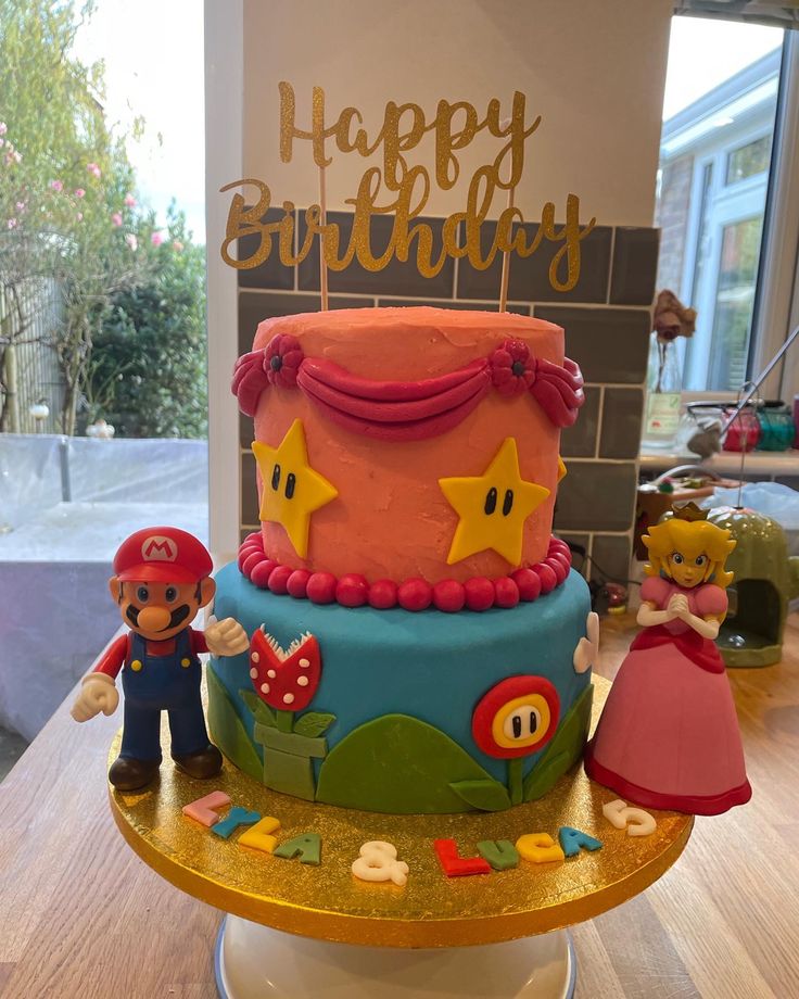 a birthday cake with mario and princess peaches on the top is sitting on a table