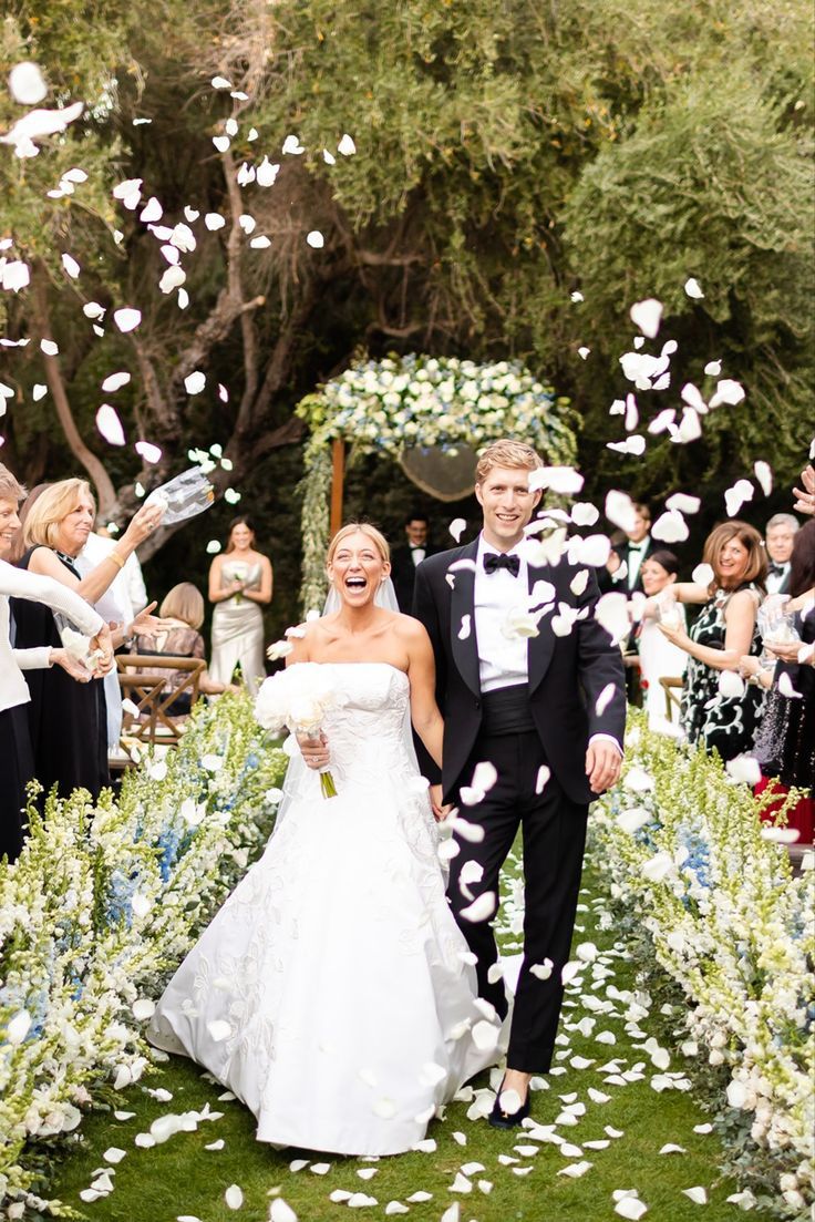 a newly married couple walking down the aisle with confetti thrown in the air