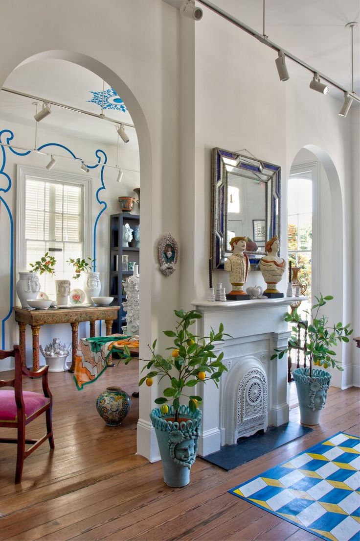 a living room filled with furniture and a fire place covered in potted plants next to a fireplace