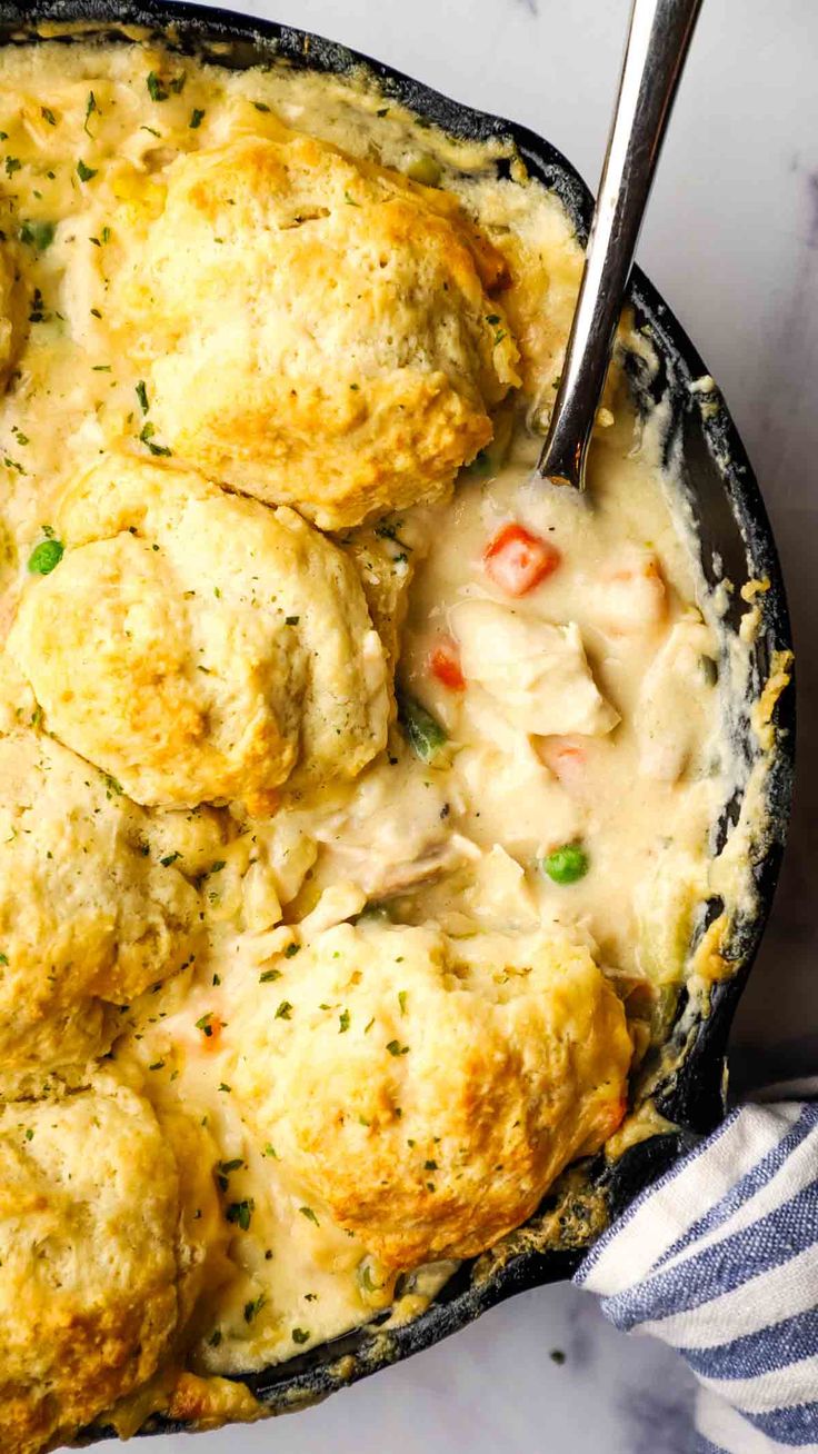 chicken pot pie casserole in a cast iron skillet with a serving spoon