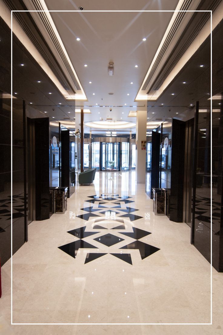 an empty lobby with black and white tiles on the floor