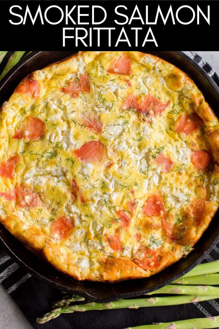 a baked pizza in a cast iron skillet with tomatoes, cheese and asparagus