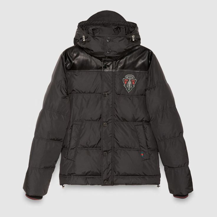 An Unique Down Jacket From Gucci Featuring Crest Logo And Leather Patchwork. Black Color Front Crest Logo Details Front Horn Bottons Detachable Hood Leather Patchwork Details Cable Knit Sleeve Rim Details 100% Polyester Shell 80% Goose Down Fill, Rest Feather Fill Luxury Gucci Hooded Outerwear, Luxury Hooded Gucci Outerwear, Gucci Black Outerwear For Streetwear, Luxury Gucci Long Sleeve Outerwear, Gucci Hooded Winter Outerwear, Gucci Hooded Outerwear For Fall, Designer Gucci Hooded Outerwear, Gucci Hooded Outerwear For Streetwear, Classic Black Gucci Outerwear