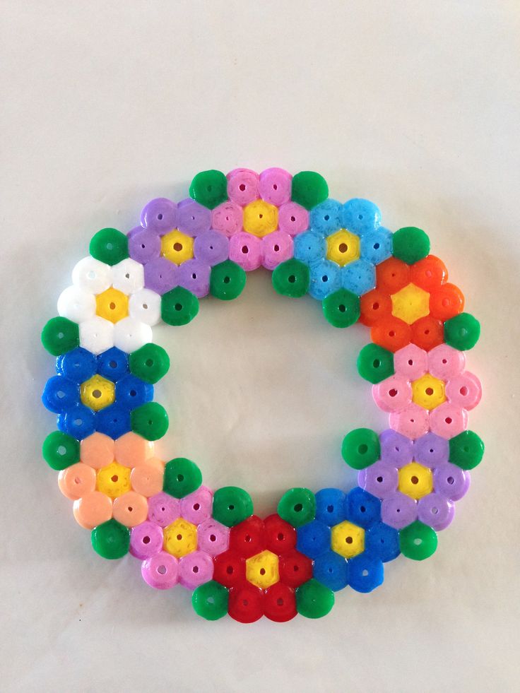 a close up of a bracelet made out of plastic buttons and flowers on a white surface