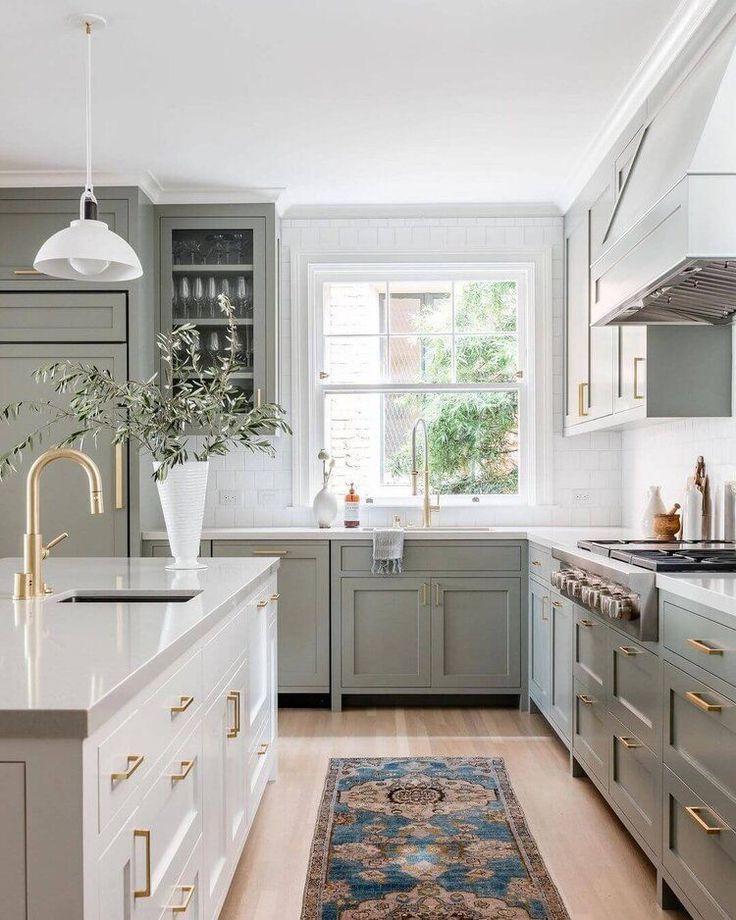 a kitchen with green cabinets, white counter tops and an area rug on the floor