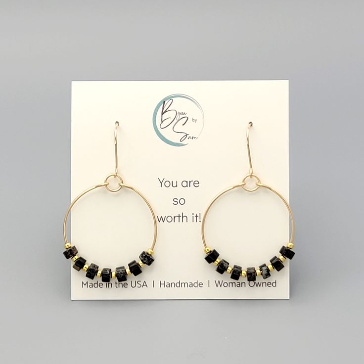 These gold hoops, adorned with black jasper beads, add a touch of eclectic elegance to any outfit. Perfect for any boho babe, these earrings are a must-have for your collection. 14k Gold Filled Wire Measure approximately 1.125" in diameter Earrings Hang 1.75" from top of ear wire Black Jasper Gemstones Polished to a high shine Sent in a Gift Box with Polishing Cloth Handmade in Montana Handmade Black Jewelry For Everyday, Handmade Black Everyday Jewelry, Black Handmade Jewelry For Everyday, Everyday Onyx Jewelry With Black Beads, Nickel-free Black Everyday Jewelry, Black Small Hoop Earrings With Ear Wire, Wire Wrapped 14k Gold Filled Hoop Earrings, 14k Gold Filled Wire Wrapped Hoop Earrings, Gold Jewelry With Black Beads