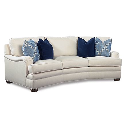 a white couch with blue pillows sitting on it's back end and arm rest