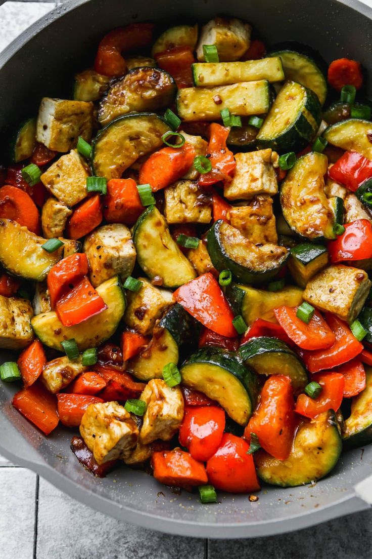 a skillet filled with vegetables and tofu