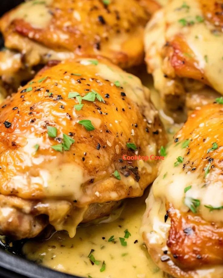 chicken with cheese sauce and parsley in a black skillet, ready to be eaten