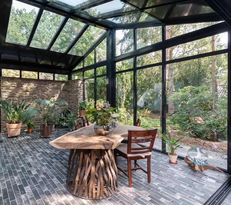 a table and chairs are in the middle of a room with glass walls on both sides