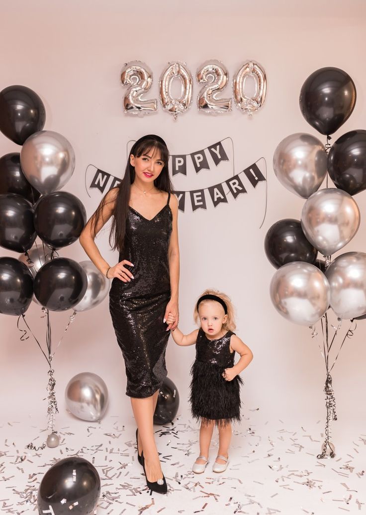 a woman and child standing in front of balloons