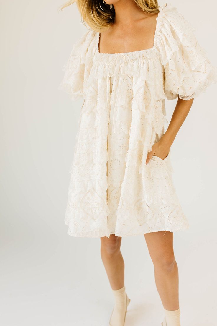 have your main character moment with this dreamy ivory puff sleeve mini dress. featuring dainty lace trim details + an elegant square neckline, this dress has heirloom-quality energy. from bridal showers to dinner dates, it’s guaranteed to be your new go-to. off white // mini length, scoop neckline, elastic neckline, lined, front bow detail, pockets, elastic cuffs model is 5'8" + wearing a small measurements are approximate + taken while laying flat xsmall : bust 32” length 31.5” small : bust 34 Puff Sleeve Mini Dress With Lace Trim For Brunch, Puff Sleeve Dress With Lace Trim For Garden Party, Puff Sleeve Mini Dress With Lace Trim, White Puff Sleeve Mini Dress With Lace Trim, White Square Neck Mini Dress In Cottagecore Style, White Square Neck Cottagecore Mini Dress, White Cottagecore Mini Dress With Square Neck, Cream Lace Trim Dress With Square Neck, Cream Lace Trim Square Neck Dress