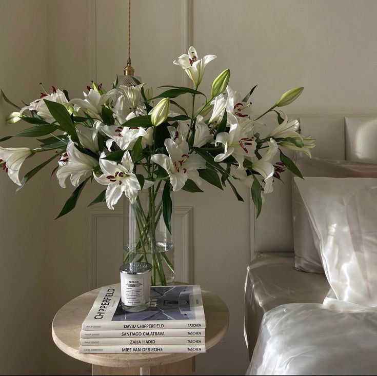 a vase filled with white flowers sitting on top of a table next to a couch