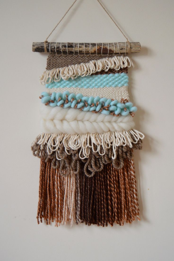 a wall hanging made out of yarn and beads