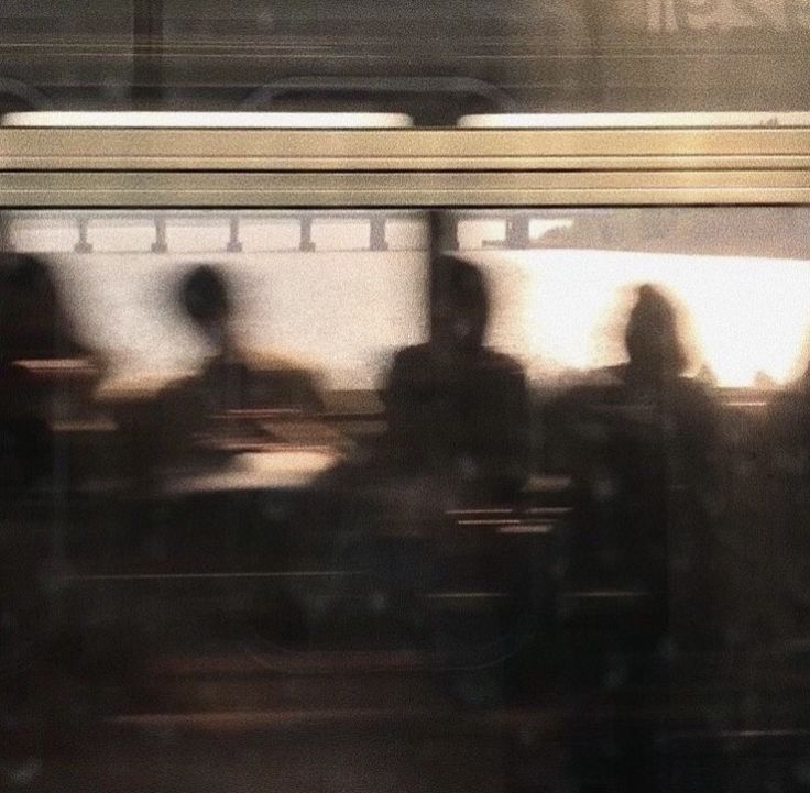 blurry image of people sitting at a table in front of a subway train window