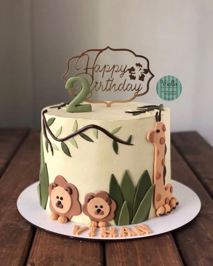 a two tiered cake decorated with animals and the number 2 on it's top