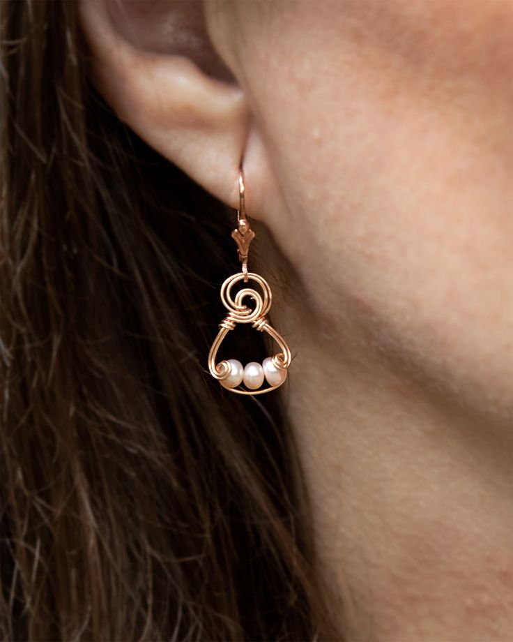 "Pretty in pink! The lovely petite pearls pair beautifully with a variety of colors and styles. I designed gentle curves and swirls of hand-formed rose gold-filled wire to complement the soft luster of the pearls. "-Laura Glen More Information 14k Rose Gold-Filled Freshwater Pearls 14K Rose Gold-Filled High-Quality lever backs Individually handmade with subtle design variations Earring is approximately 5/8" tall Each pearl is unique, with subtle variations Wire Wrapped Earrings Heart, Small Wire Wrapped Earrings, Ethereal Jewelry, Diy Wire Earrings, Wire Jewellery, Wire Wrapped Jewelry Tutorials, Earrings Wire, Freshwater Pearls Earrings, Handmade Wire Jewelry