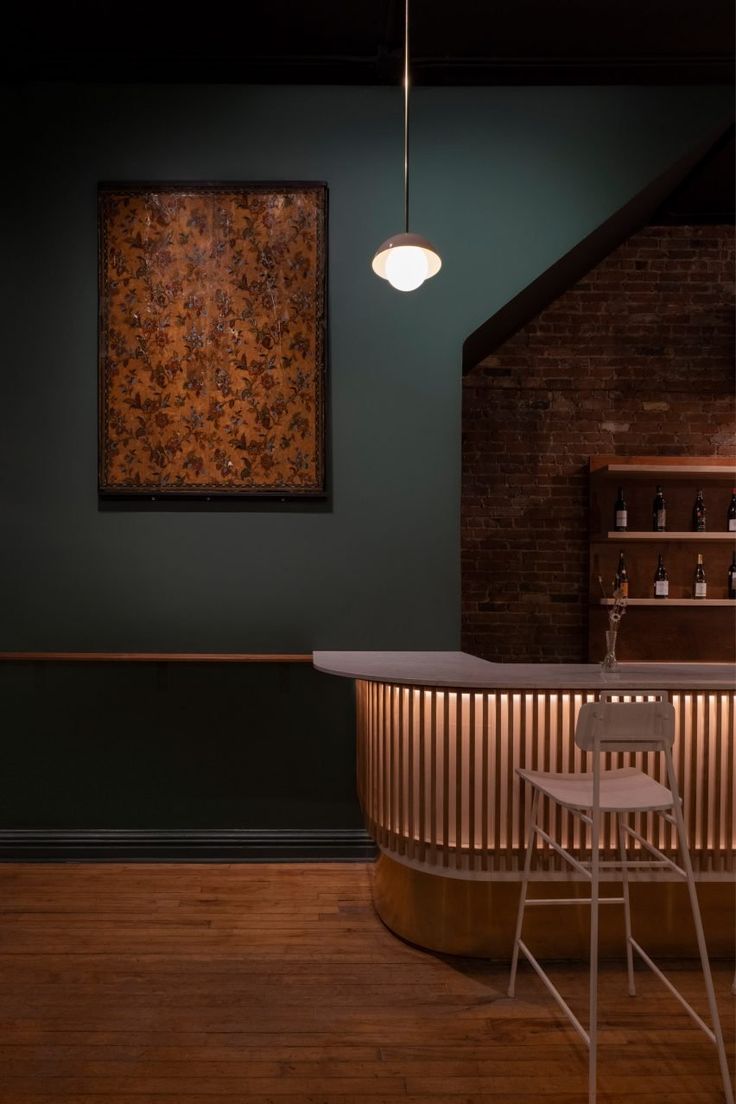 a bar with stools next to it and a painting on the wall