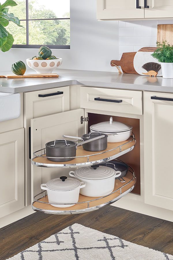 an open kitchen cabinet with pots and pans