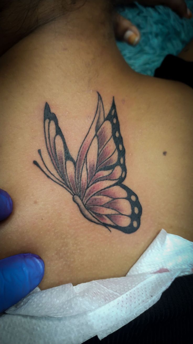 a woman with a butterfly tattoo on her back