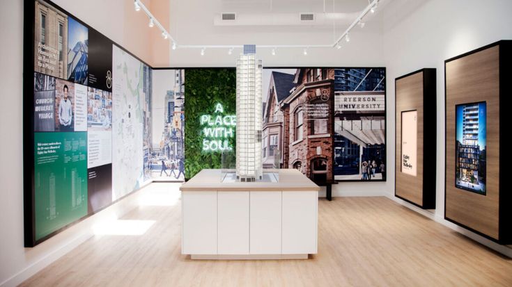 an empty room with posters on the wall and wooden flooring, along with white counter tops