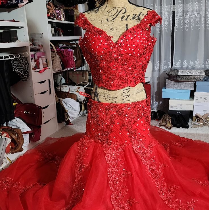 two piece red prom dress with sequins on the top and bottom, in front of a closet