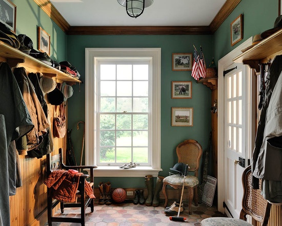 a room filled with lots of wooden shelves next to a large window and a white door