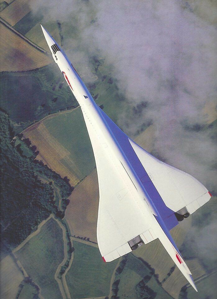 an aerial view of a jet flying in the sky with clouds around it and land below