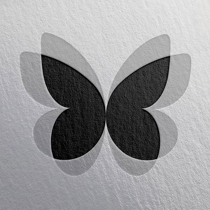 a black and white butterfly logo is shown on a piece of paper that has been cut in half