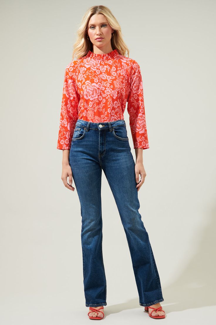 Even on the most casual days, you'll be boasting with main character energy when you're wearing the Tiana Floral Astana Mock Neck Blouse! A bright, floral print decorates this blouse that features long sleeves, a mock neck and a super cute bow tie back. You'll create a dynamite duo when you style this top with your favorite jeans! - Mock neck- Long sleeves- Back bow tie - Relaxed fit- Color: Red PinkSize + Fit - Model is 5'8" and wearing size XS- Measurements taken from size S - Chest: 19 1/2"- Spring Floral Print Long Sleeve Tops, Relaxed Fit Long Sleeve Tops With Floral Print, Spring Top With Vibrant Print And Stretch, Spring Tops With Vibrant Print And Stretch, Stretch Floral Print Blouse For Spring, Spring Stretch Tops With Vibrant Print, Floral Print Long Sleeve Top With Relaxed Fit, Stretch Spring Top With Vibrant Print, Long Sleeve Blouse With Floral Print And Relaxed Fit