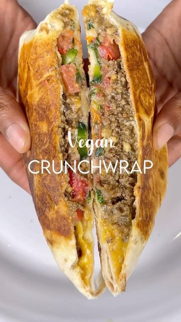 a person holding a sandwich in their hands with the words vegan crunchwrap