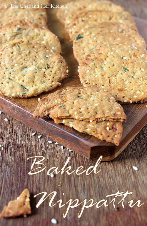 baked appetizers on a wooden cutting board with sesame seeds scattered around the edges